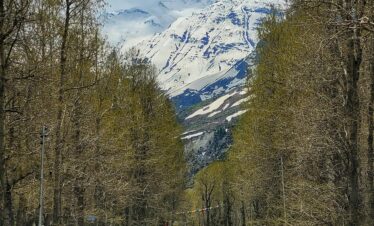 Beautiful view of the Manali Leh Highway passing through Sissu village surrounded by snow-capped mountains