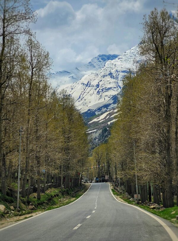 Beautiful view of the Manali Leh Highway passing through Sissu village surrounded by snow-capped mountains