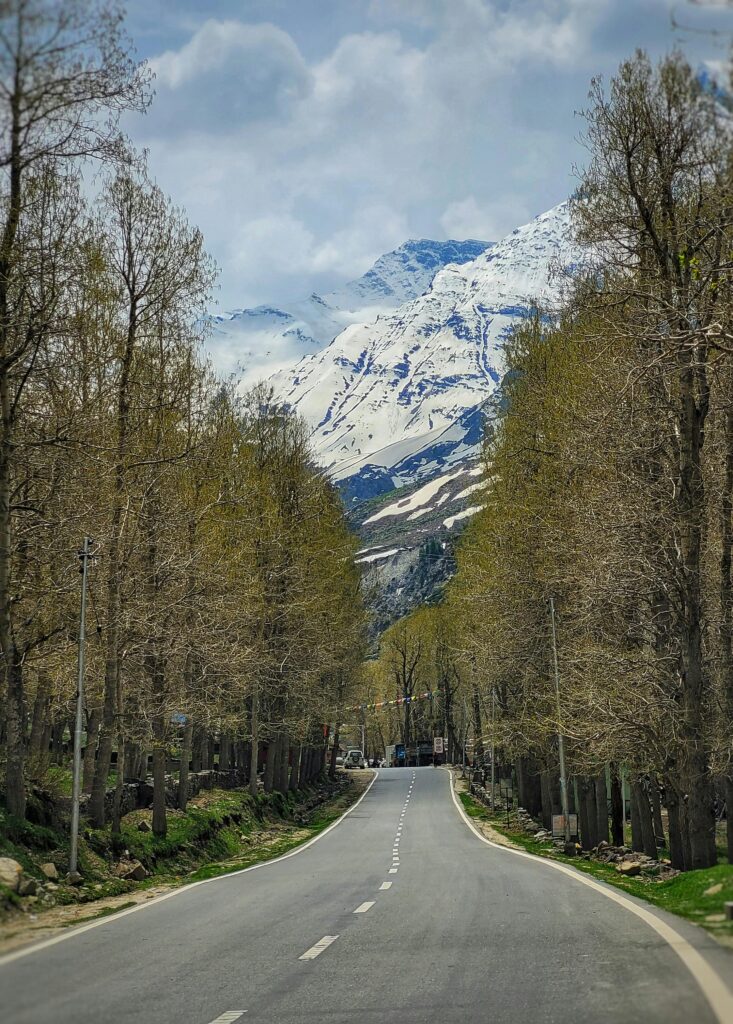 Beautiful view of the Manali Leh Highway passing through Sissu village surrounded by snow-capped mountains